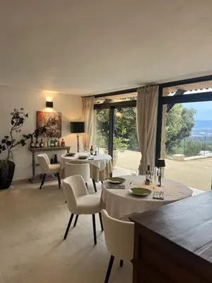 a dining room with tables and chairs and a large window at La Villa des Cedres in Bonnieux