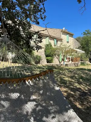 a hammock in a yard in front of a house at Authentique mas provençal avec piscine in Beaumont-de-Pertuis