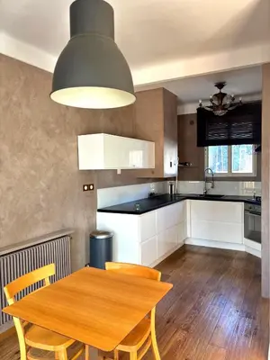 a kitchen with a wooden table and chairs in it at Paul Cézanne garden apartment with air conditioning in Aix-en-Provence