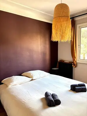 a bedroom with a bed with two towels on it at Paul Cézanne garden apartment with air conditioning in Aix-en-Provence