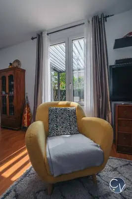a yellow chair in a living room with a window at Maison entière à 300m du centre in LʼIsle-sur-la-Sorgue