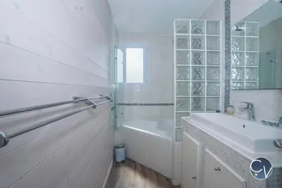 a white bathroom with a tub and a sink and a bath tub at Maison entière à 300m du centre in LʼIsle-sur-la-Sorgue