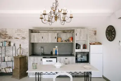 a kitchen with a white refrigerator and a table at The Aviary - Pernes-les-Fontaines in Pernes-les-Fontaines