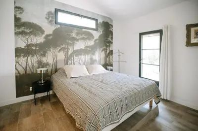 a bedroom with a bed with a painting on the wall at The Aviary - Pernes-les-Fontaines in Pernes-les-Fontaines