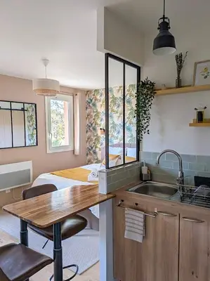a kitchen with a sink and a bedroom with a bed at Le Colibri - studio paisible et raffiné au sud d'Aix in Aix-en-Provence