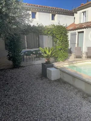 a backyard with a pool and a table and chairs at Mas provençal au coeur de L'Isle-sur-la-Sorgue in LʼIsle-sur-la-Sorgue