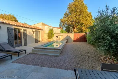 a backyard with a swimming pool and a house at Mas provençal au coeur de L'Isle-sur-la-Sorgue in LʼIsle-sur-la-Sorgue