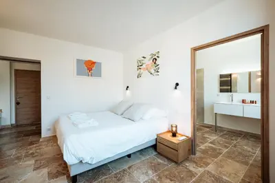 a white bedroom with a bed and a mirror at La Source Blanche in Gargas
