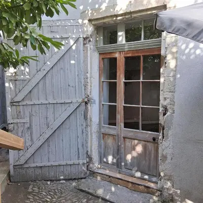 an old wooden door with a window on a building at gîtes carita in Cabannes