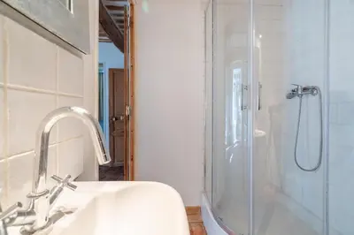 a white bathroom with a shower and a sink at gîtes carita in Cabannes