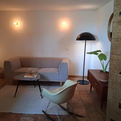a living room with a couch and a lamp at gîtes carita in Cabannes