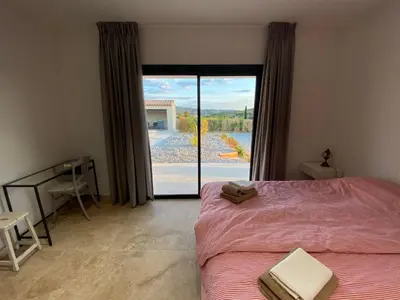 a bedroom with a bed and a large glass door at Villa with pool in Provence bij de Mont Ventoux in Blauvac