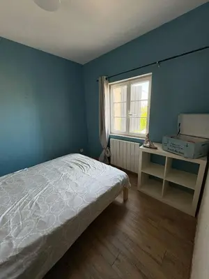 a blue bedroom with a bed and a window at Mas Bourbon in Cavaillon