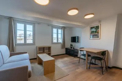 a living room with a couch and a table at Studio climatisé plein centre 4eme étage in Aix-en-Provence