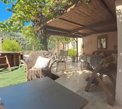 a patio with wicker chairs and a wooden pergola at alize gîte en Provence in Jonquerettes