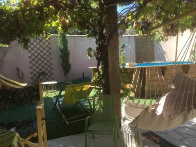 a hammock in a backyard with a tree at alize gîte en Provence in Jonquerettes