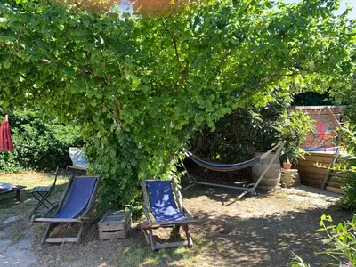 two chairs and a hammock under a tree at Chambres et table d'hôtes Au Brabo in Mormoiron