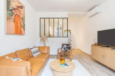 a living room with a couch and a tv at T3 proche cardeurs clim centre ville in Aix-en-Provence