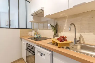a kitchen with a sink and a bowl of fruit on the counter at T3 proche cardeurs clim centre ville in Aix-en-Provence