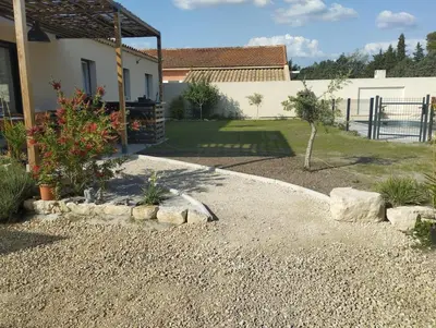 a garden with rocks and a yard with a house at villa zen en provence in Velleron