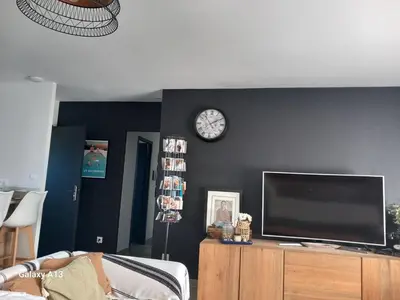 a living room with a tv and a clock on a wall at villa zen en provence in Velleron