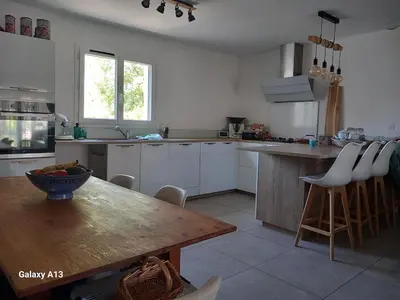a kitchen with a wooden table and a dining room at villa zen en provence in Velleron