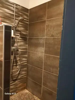 a shower in a bathroom with a tile wall at villa zen en provence in Velleron