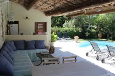 a living room with a blue couch and a pool at Gîte une treille en provence in Saint-Didier