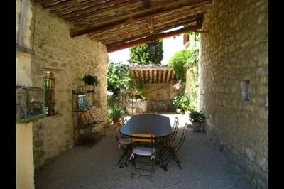 a patio with a table and chairs in a building at Gîte une treille en provence in Saint-Didier