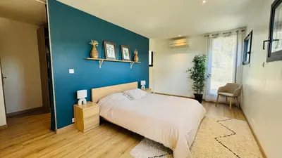 a bedroom with a blue wall and a bed at Le Secret des Pins in Pernes-les-Fontaines