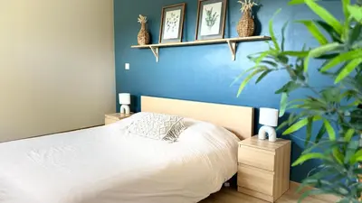 a bedroom with a bed and a blue wall at Le Secret des Pins in Pernes-les-Fontaines