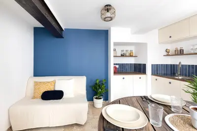 a living room with a white couch and a blue wall at Suite Bleu d'Azur - Hypercentre - Wifi in Apt