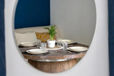 a table with plates and glasses in front of a mirror at Suite Bleu d'Azur - Hypercentre - Wifi in Apt