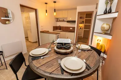 a dining room table with plates and a laptop on it at Suite Terre d'Ocre - Hypercentre - Wifi in Apt