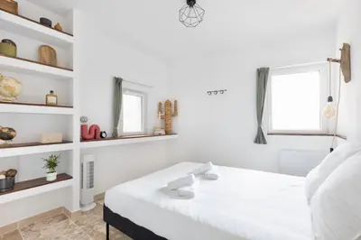 a white bedroom with a bed and a window at Suite Vert Provence - Hypercentre - Wifi in Apt