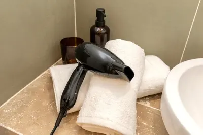 a blow dryer sitting on a towel in a bathroom at Suite Vert Provence - Hypercentre - Wifi in Apt