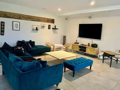 a living room with two blue couches and a flat screen tv at Le Mas des platanes-piscine-gîte-Clim-parking in Monteux