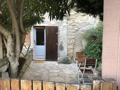a wooden door with a bench in front of a house at studio au coeur de Lacoste in Lacoste