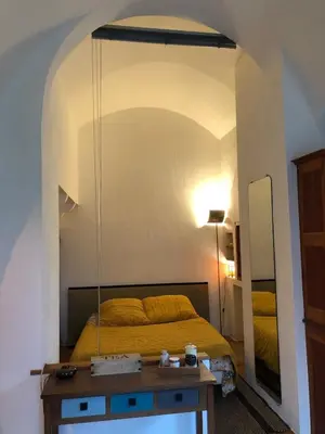 a bedroom with a bed and a mirror at studio au coeur de Lacoste in Lacoste