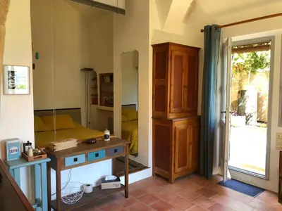 a bedroom with a bed and a table and a mirror at studio au coeur de Lacoste in Lacoste