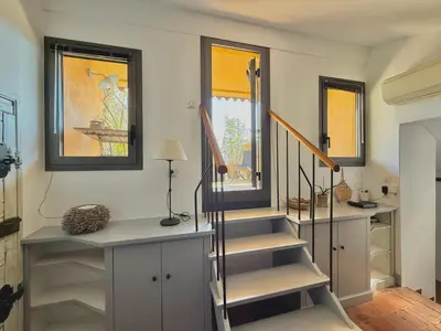 a staircase in a room with windows and a stair case at Le Sainte-Victoire - Studio cosy avec sa jolie terrasse - Centre ville historique in Aix-en-Provence