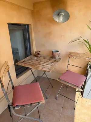 two chairs and a table in a room with a mirror at Le Sainte-Victoire - Studio cosy avec sa jolie terrasse - Centre ville historique in Aix-en-Provence