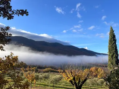 a foggy valley with mountains in the background at Le Grand Hermas in Saint-Martin-de-Castillon