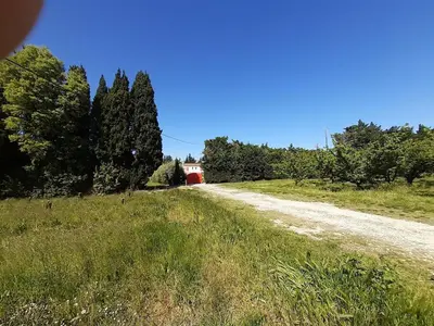a dirt road with a red barn in the distance at 4 bedroom villa pool entire place in Salon-de-Provence