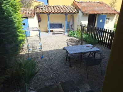 a backyard with a swing and a table and a bench at Le Portail Vert in Villes-sur-Auzon