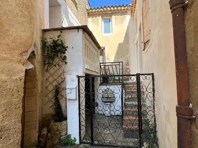 an alley with a gate and a table on a balcony at Maison cosy en Provence Proche Golf Pont Royal in Alleins
