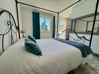 a bedroom with a large white bed with blue pillows at Mas d'Andiol in Plan-dʼOrgon