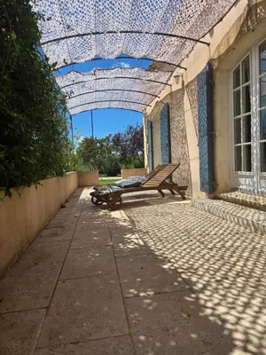a patio with a bench under a glass ceiling at Luboregard in Cheval-Blanc