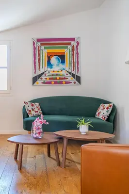 a living room with a green couch and two tables at Le Chastel, T3, Aix Centre Ville in Aix-en-Provence