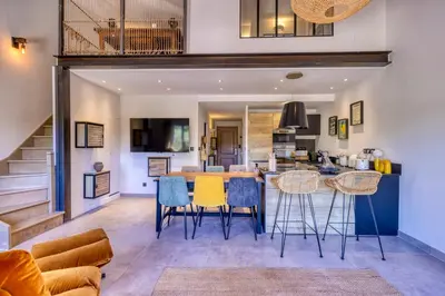 a kitchen and living room with a table and chairs at VILLA Isle sur la Sorgue in LʼIsle-sur-la-Sorgue